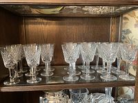 Shelf displaying 12 cut crystal glasses in two rows, showing the diamond pattern and stem.
