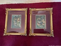 Two framed still life fruit prints lying on carpet, showing full view of both artworks and frames.