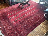Full view of rug on parquet floor showing overall pattern and condition