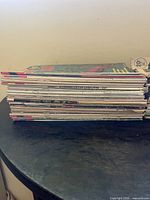 Side view stack of approximately 35 comic books showing titles and spines.