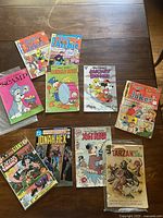 Photo of 10 vintage comic books including Reggie's Jokes, Archie, Donald Duck, Mickey Mouse, Jonah Hex, Yogi Bear, and Tarzan titles.