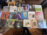 Photo showing 20 assorted vinyl records with their album covers laid out, various artists and styles visible.