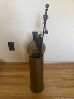 Image showing cylindrical container with fireplace tools and bellows inside