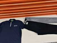 Full lot showing navy blue Hugo Boss polo shirt and two pairs of jeans, one black and one grey