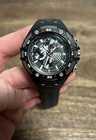 Front view of a Roots men's black sport watch showing the dial and strap details.