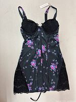 Full view of black floral night dress with lace cups and hem against grey background