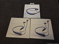 Three wireless Bluetooth headset boxes including one Samsung Level U and two Sol Republic Shadow Wireless in their original packaging on a dark surface.