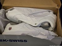 Photo showing pair of white K-Swiss men's sneakers in original box with tissue paper included.