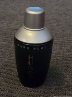 Front view of Hugo Boss Dark Blue bottle with silver cap on fabric surface.