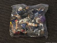 Sealed translucent bag containing multiple assorted Lil Homies figurines with visible details of characters, outfits, and colors.