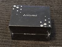 Top view of black box with Syllable logo and white dot design showing packing condition.