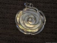Front of pendant showing detailed mother of pearl rose design set in sterling silver