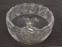 Overall view of clear crystal bowl with swirl design and scalloped edge