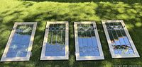 Four window panels laid out on grass showing full set