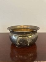 Side view of the vintage brass planter showing the twisted rope and tassel detail on the exterior surface.