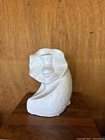Front view of vintage white ceramic monkey figurine showing stylized facial details and textured body