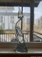 Full front view of the clear crystal bird sculpture on a window sill