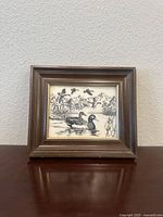 Front view of the framed porcelain tile showing the waterfowl scene and overall frame design