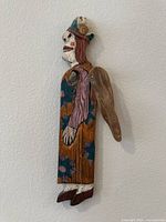 Side angle photo of the vintage wooden winged woman wall sculpture showing profile, hand-painted details, and attached wooden wing.