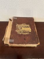 Photo showing front cover of the book with embossing and gold lettering titled "Pictures from the Garden of the World".