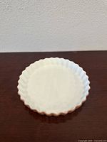 Top-down view of the round fluted porcelain baking dish showing white interior and orange exterior