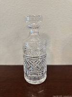 Front view of the vintage Waterford crystal decanter and stopper set showing the intricate criss cross and star cut pattern on clear crystal.