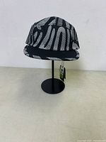 Front view of Ciele Athletics GOCap showing black and white abstract pattern and softcurve brim on display stand.