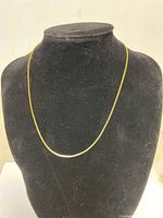 Front view of the gold toned box chain necklace displayed on a black velvet bust.
