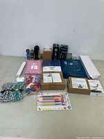 Overview of all miscellaneous new items on white surface including pens, fabrics, boxes, scrunchies, figurines.