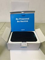 Opened box showing Reolink solar panel inside unwrapped and in protective case with brand messaging visible.