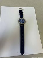 Full view of the Vostok wristwatch laid flat on white background, showing blue dial and nylon strap.