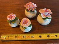 Four Aynsley fine bone china salt and pepper shakers with pink flower tops displayed next to measuring tape showing size around 3 inches tall.