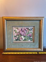 Gold framed artwork with floral tulip print and measuring tape shown for scale.