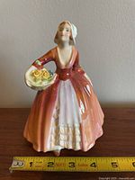 Front view of Royal Doulton Janet figurine with measuring tape showing about 6 inches tall.