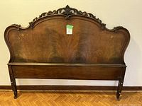 Full view of the antique wooden headboard showing overall shape, finish, and size.
