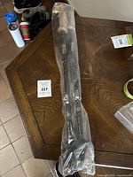 Two Backwoods Trekk walking sticks in original plastic packaging on a wooden table.