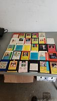 Full lot of 29 colorful 8-track tapes arranged on a table showing various album covers and labels.