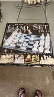 Full top view of the closed box showing glass chess pieces arranged on the board image printed on the box.