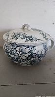 Photo of the chamber pot showing blue floral pattern and lid with handle.