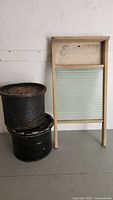 Photo of antique wooden washboard alongside two black perforated minnow buckets showing overall condition and size