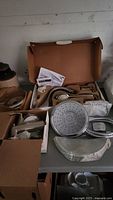 Various new Moen shower heads and components in original boxes on table