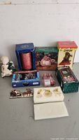 Overview of all Christmas items in original boxes showing various ornaments, candles, figurines, and decorations including a white angel figurine.