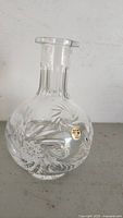 Full view of the clear lead crystal vase with engraved floral patterns and a label indicating 24% lead content.