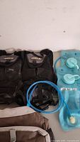 Two black North 49 hydration packs with 1.5L reservoirs and blue drinking tubes, showing minor wear.