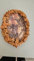 Front of the collector plate showing the wolf image with sculpted leaf frame.