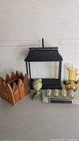 Full set of six pieces including wooden planter, black lantern, green owl vase, tealight holder, garden stakes, and amber glass pitcher