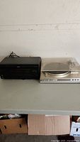 Front view of Sony surround sound receiver and black Sony DVD player next to a silver direct drive turntable with dust cover.