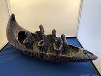 Side angled view of the ceramic boat sculpture showing six of the figures and textured finish.