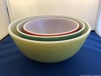 Side view of three nested Pyrex bowls showing yellow, green, and red colors.