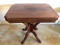 Front view of rectangular wooden table top with beveled edge and decorative carved details, showing natural wood grain and surface wear.